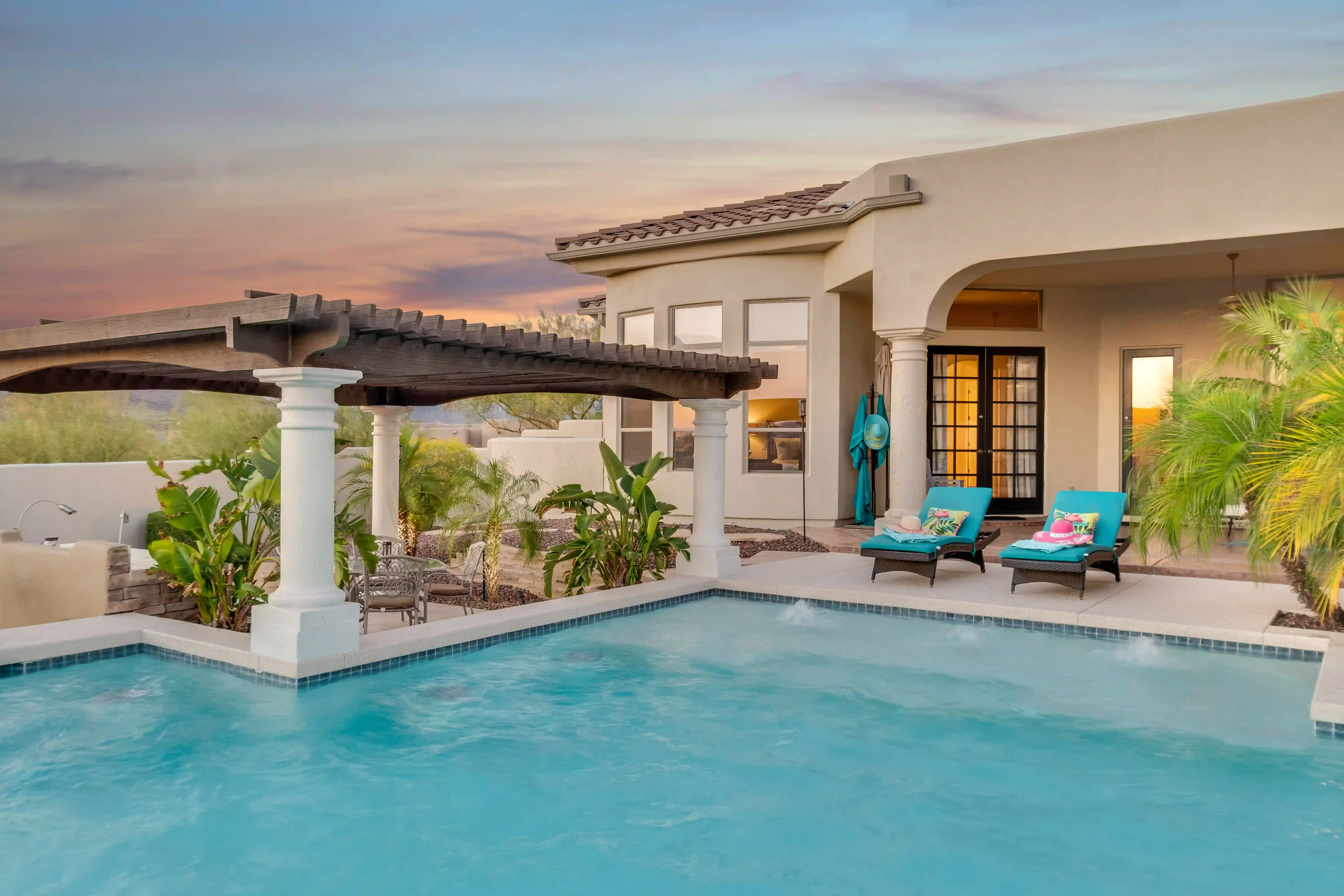 a home during twilight with a pool in the foreground
